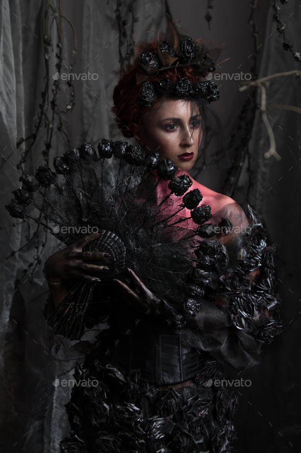 Dark queen in black fantasy costume on dark gothic background