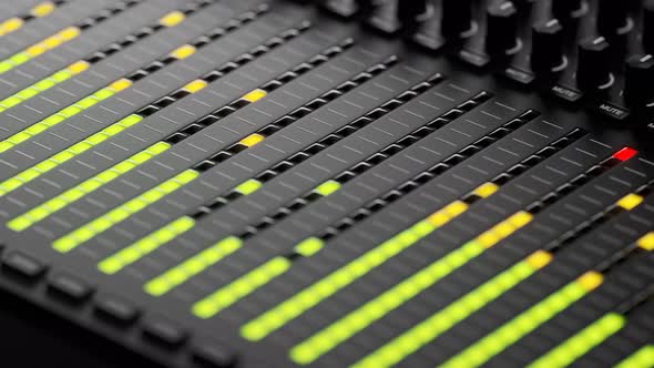 Colorful led lights indicating sound volume levels on a studio mixer. 4KHD
