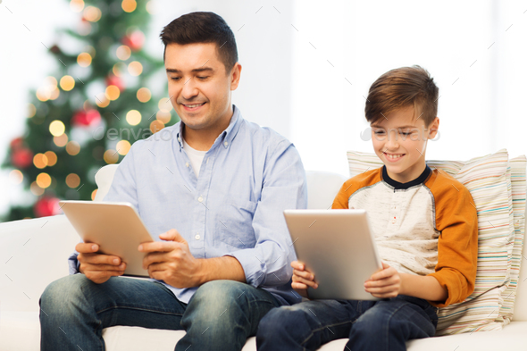 happy father and son with tablet pc at christmas