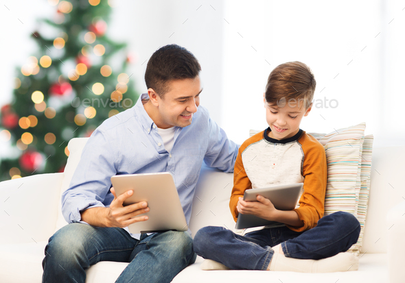 happy father and son with tablet pc at christmas