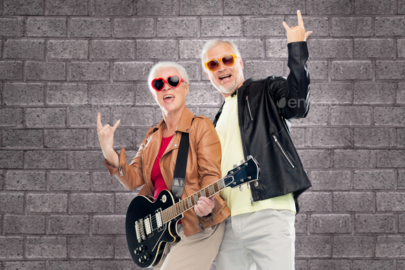 senior couple with guitar showing rock hand sign