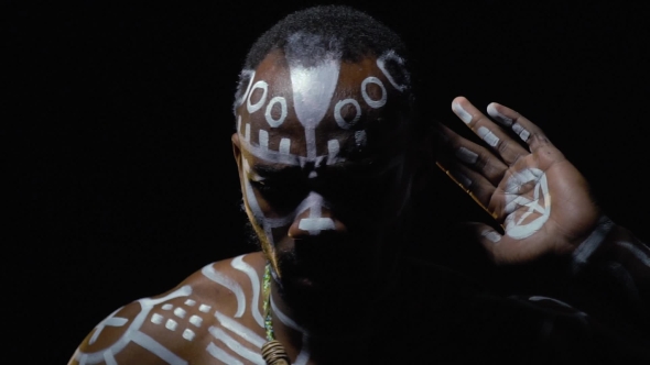 Bearded Papuan in White Ritual Patterns Looking for Someone in the Dark alt