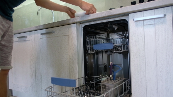 Man Puts Dishes in the Dishwasher