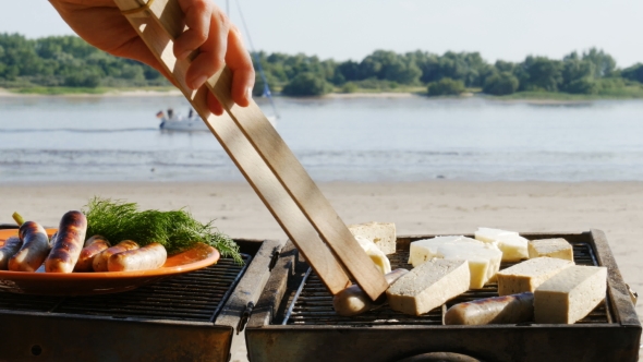 Barbecue - Grilling Sausages and Tofu on a River Beach