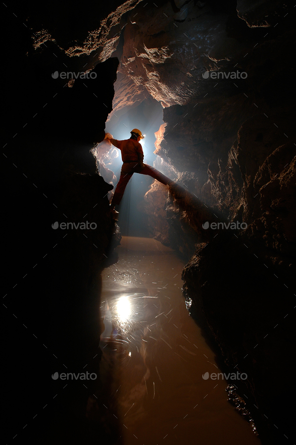 Spelunker exploring a cave - Stock Photo - Images