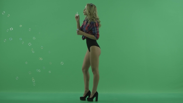 Young Sexy Cheerful Woman Blowing Bubbles in Full Body Shot Over Chroma Key