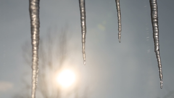 Icicles Melt Through the Window As the Sun Rises in the Background