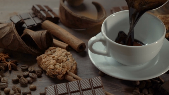 Cup of Hot Chocolate with Cinnamon Sticks, Chocolate Slices and Cookies on Old Wooden Table