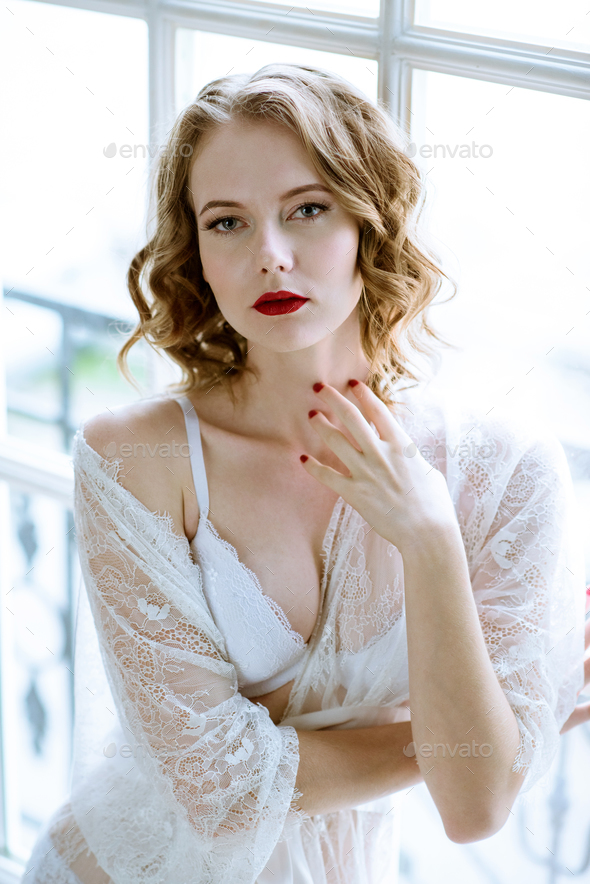 Fashionable female portrait of cute lady in white robe indoors - Stock Photo - Images