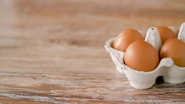 Close Up of Eggs in Cardboard Box on Wooden Table alt