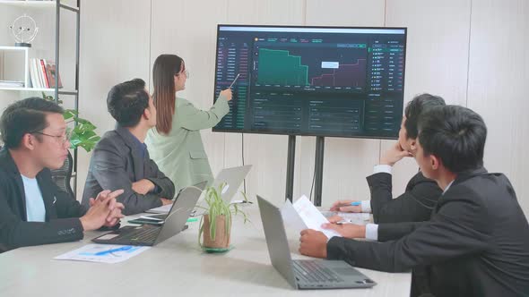 Asian Businesswoman Presentation To Business Colleagues About Financial Chart Trading Online On Tv alt