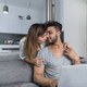 Beautiful Woman Kiss Man Sitting On Couch With Laptop Computer In Modern Apartment Young Couple - PhotoDune Item for Sale