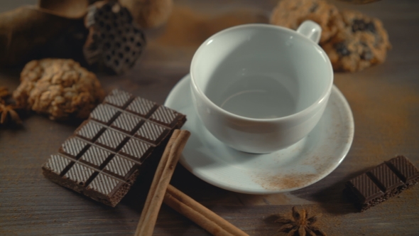 Cup of Hot Chocolate, Cinnamon Sticks and Chocolate on Wooden Table