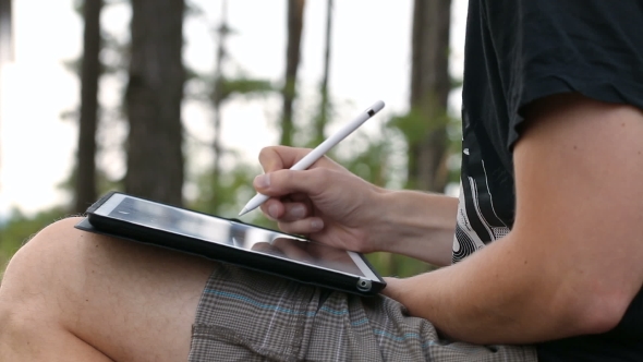 Designer Drawing and Scaling On Tablet Using Stylus on Nature