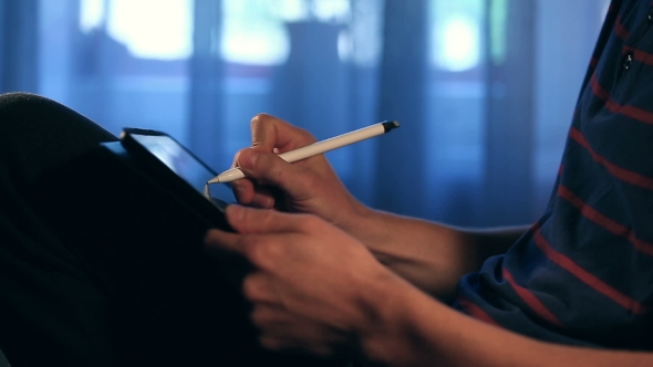 Artist Drawing a Sketch Using His Tablet with Stylus at Home