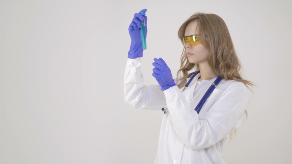 Beautiful Doctor in Protective Glasses Is Working with a Test Tube