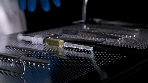 the Surgeon Takes a Scalpel From the Table with the Tools for the Operation alt