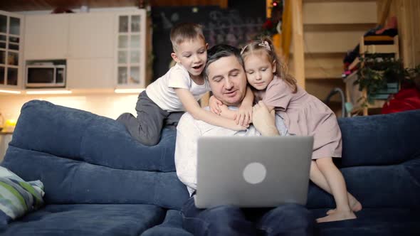 Family Dad and Childres Watching Something on Laptop in Living Room at Home