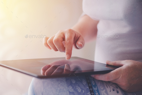 Close up of female finger pushing digital tablet touch screen