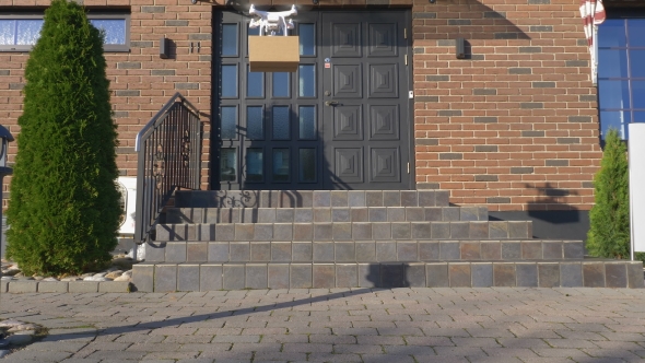 Drone Delivers a Package in Front of a House