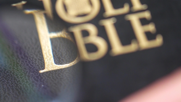 Looking for Holy Bible with Magnifying Glass