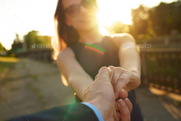 Follow me - happy young woman pulling guy's hand - hand in hand - Stock Photo - Images