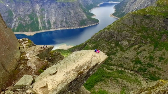 Guy and Girl Sitting on the Edge of the Trolltunga
