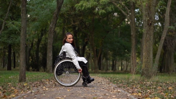 Attractive Girl on a Wheelchair Walking in the Autumn Park