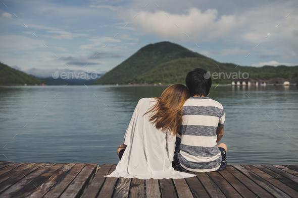 Young couple sitting on wooden pier