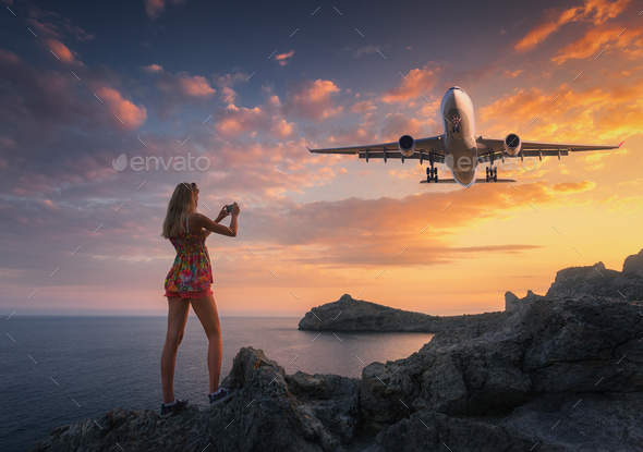 Beutiful woman makes photo of landing aircraft