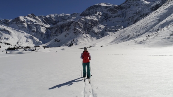 Female Skier Cross-country Skiing in Mountains