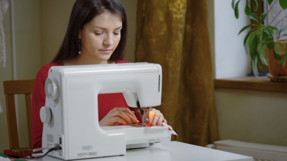 professional seamstress working on sewing machine