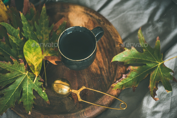 Mug of tea with sieve and colofrul autumn leaves - Stock Photo - Images