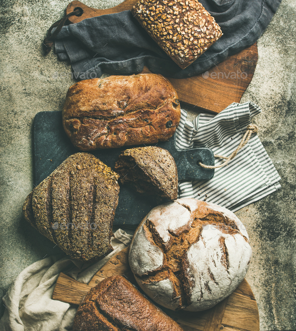Flat-lay of various bread loaves on grey background, top view - Stock Photo - Images
