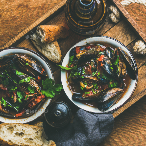 Belgian boiled mussels in tomato sauce with parsley in tray - Stock Photo - Images