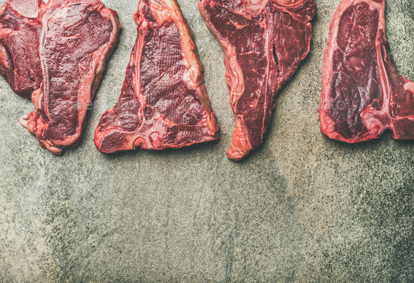 Flat-lay of fresh raw beef meat steaks over concrete background - Stock Photo - Images