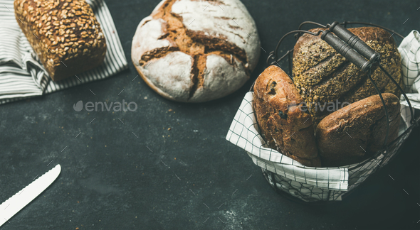 Various bread loaves over black background, copy space, horizontal composition - Stock Photo - Images
