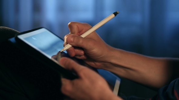 Designer Create a Sketch on His Tablet Using a Stylus at Home.