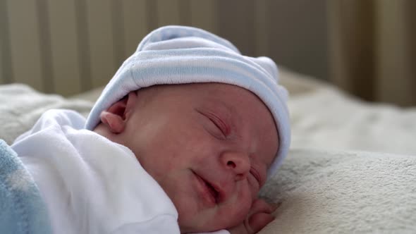 Closeup Newborn Baby Face Portrait Early Days Sleeping Sweetly On Tummy Blue White Background alt