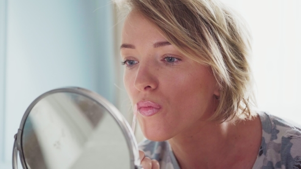 Adult Woman Makes Makeup Applying Lipstick
