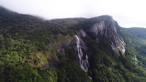 Aerial View in Motion of Waterfall and Forest in Mountains on Adam Peak in Sri Lanka alt