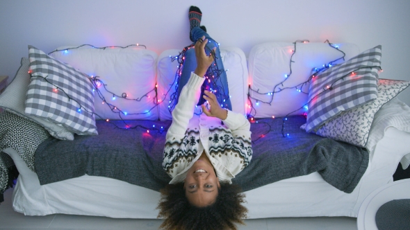 Smiling Woman on Sofa with Twinkle Lights alt