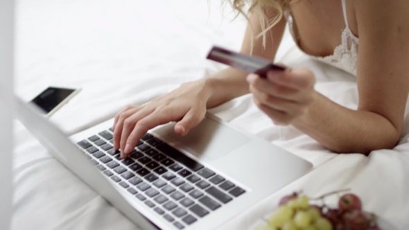 Gorgeous Woman Using Laptop and Credit Card for Shopping Online on Bed