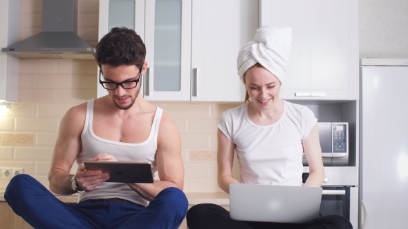 Young Business Couple in Home Clothes Works at Home and Enjoys Successful Sales. alt