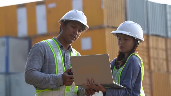 Two logistic staff checking and control loading containers box from cargo