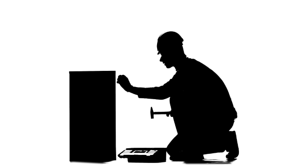 Builder in a Helmet Hammers a Nail with a Hammer. Silhouette. White Background alt