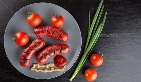 Fried sausages on a plate with tomatoes and ketchup - Stock Photo - Images