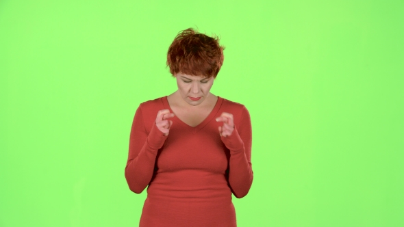 Red Haired Woman Folded Her Fingers in Her Arms in the Hope of Victory. Green Screen alt