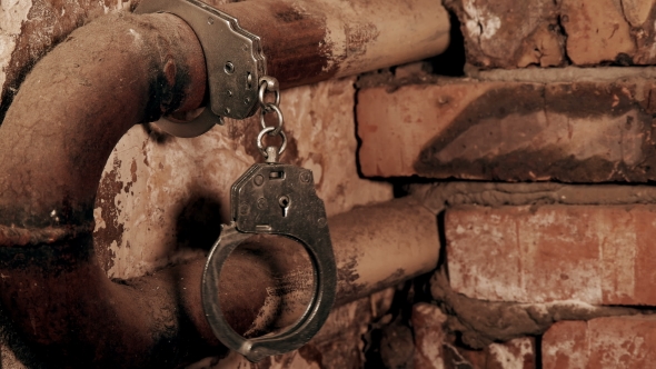 the Handcuffs Chained To a Pipe in an Old Building alt