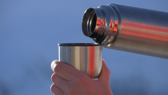 Pouring Tea From a Thermos Into a Mug